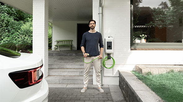 Mann steht neben E-Auto