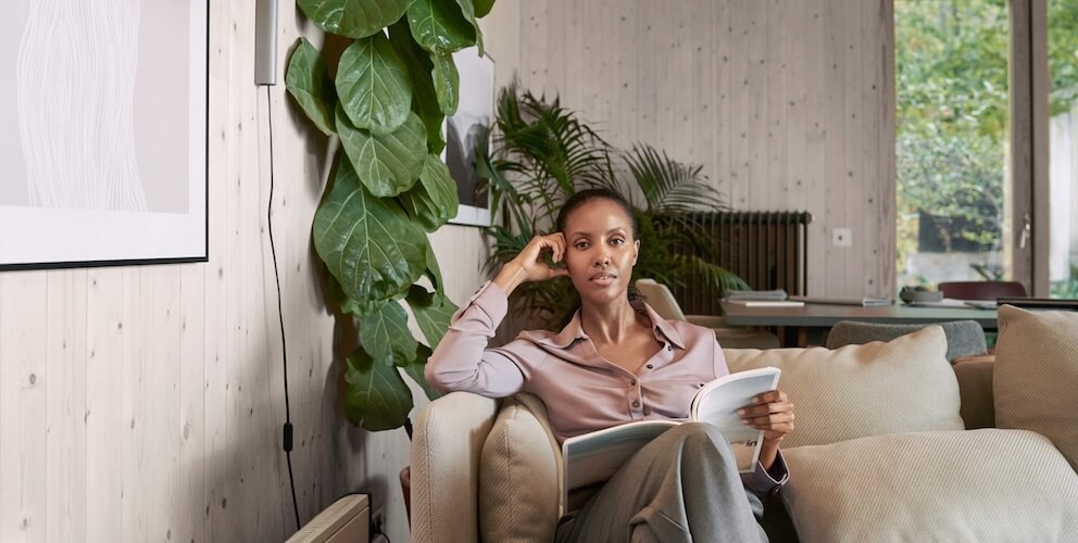 Frau sitzt mit Buch auf der Couch