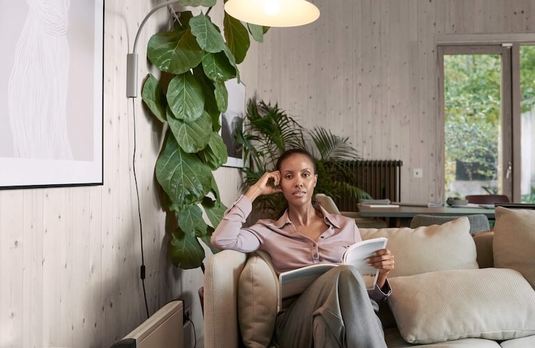 Frau sitzt mit Buch auf der Couch