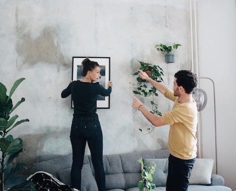 Frau und Mann bringen ein Bild an  die Wand
