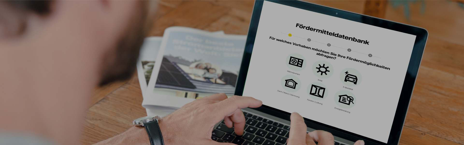 Ein Mann tippt auf einem Laptop. Er hat die Webseite von Vattenfall geöffnet. Man kann die Überschrift "Fördermitteldatenbank" deutlich erkennen.