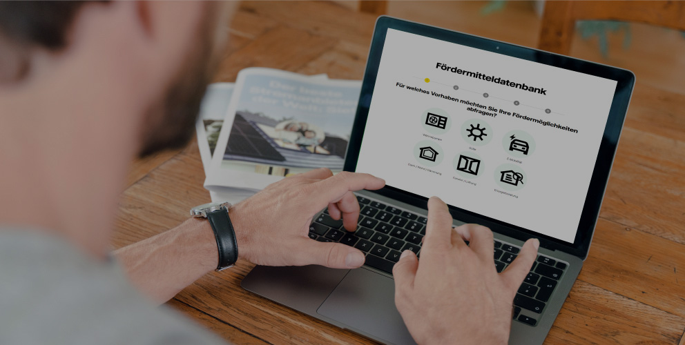 Ein Mann tippt auf einem Laptop. Er hat die Webseite von Vattenfall geöffnet. Man kann die Überschrift "Fördermitteldatenbank" deutlich erkennen.