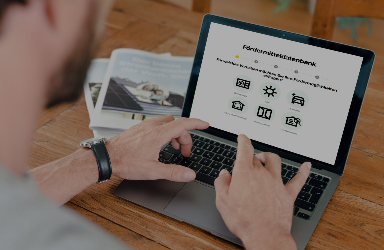 Ein Mann tippt auf einem Laptop. Er hat die Webseite von Vattenfall geöffnet. Man kann die Überschrift "Fördermitteldatenbank" deutlich erkennen.