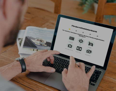 Ein Mann tippt auf einem Laptop. Er hat die Webseite von Vattenfall geöffnet. Man kann die Überschrift "Fördermitteldatenbank" deutlich erkennen.