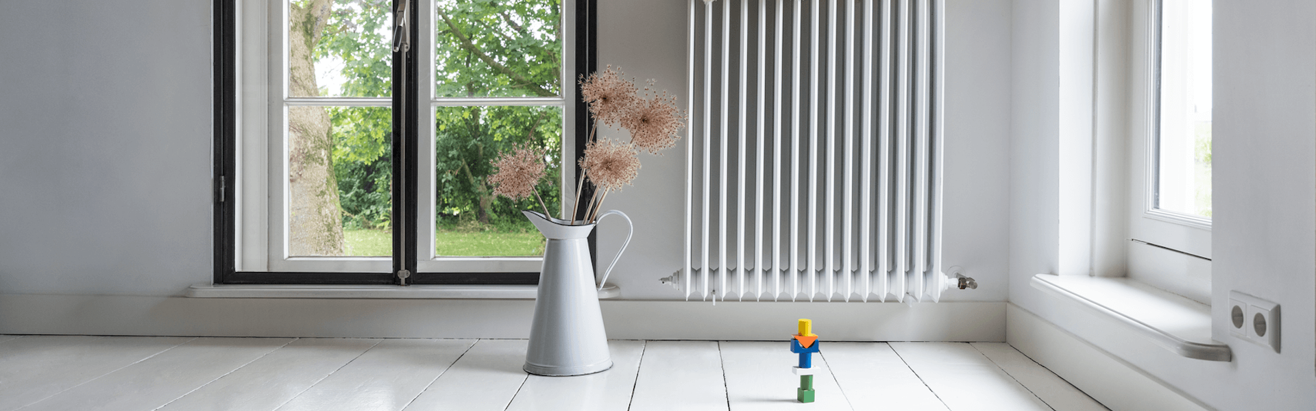 Langer Heizkörper an der Wand eines Altbau-Wohnzimmers