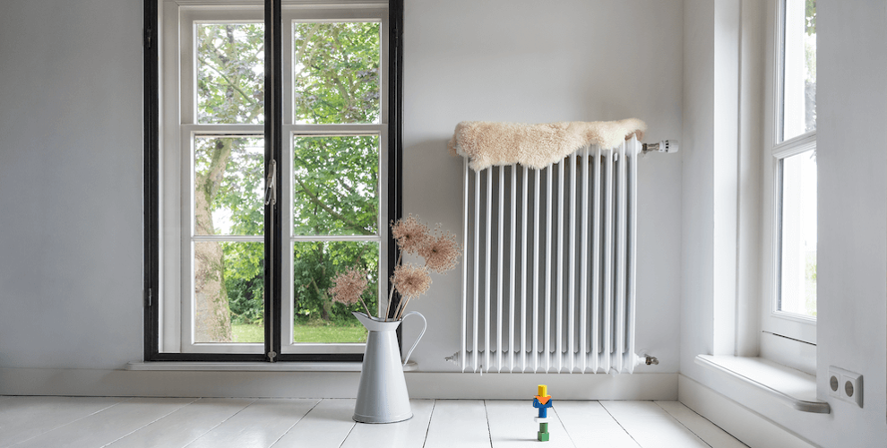 Langer Heizkörper an der Wand eines Altbau-Wohnzimmers