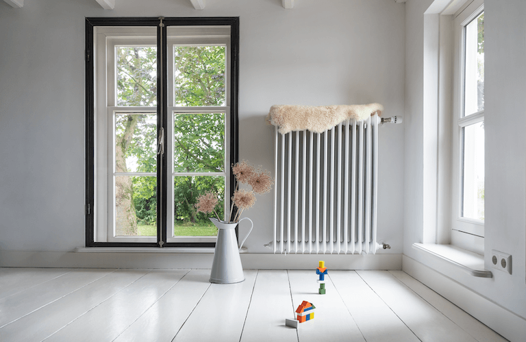 Langer Heizkörper an der Wand eines Altbau-Wohnzimmers