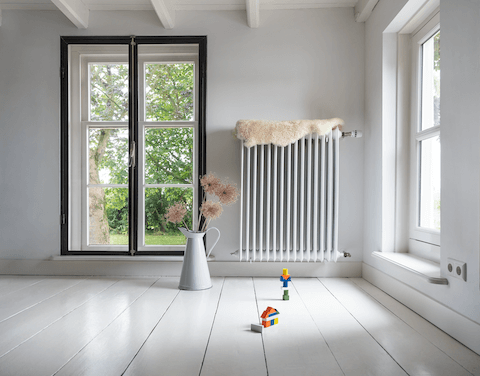 Langer Heizkörper an der Wand eines Altbau-Wohnzimmers