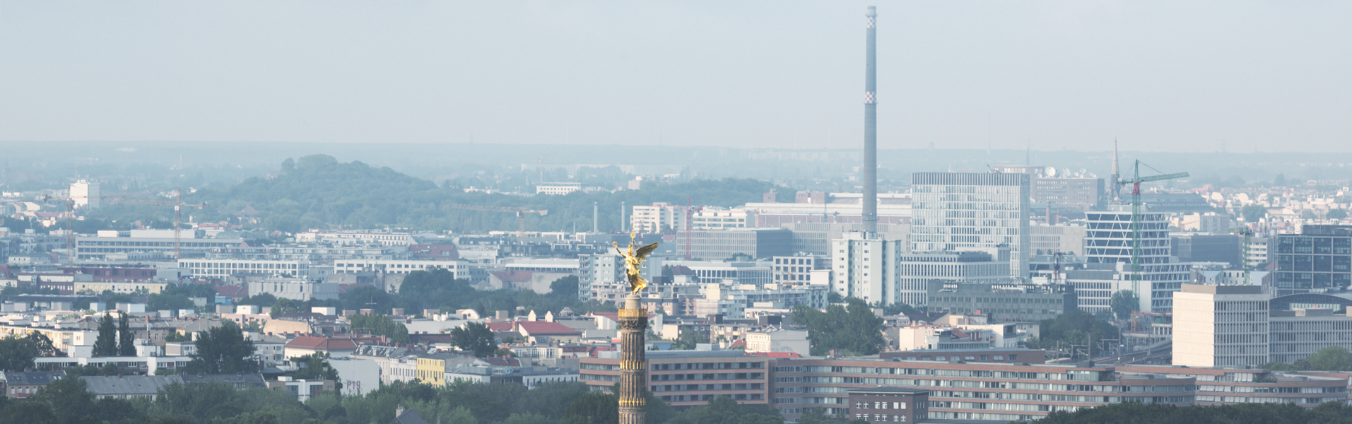 Blick über die Skyline von Berlin mit der goldenen Siegessäule im Vordergrund.