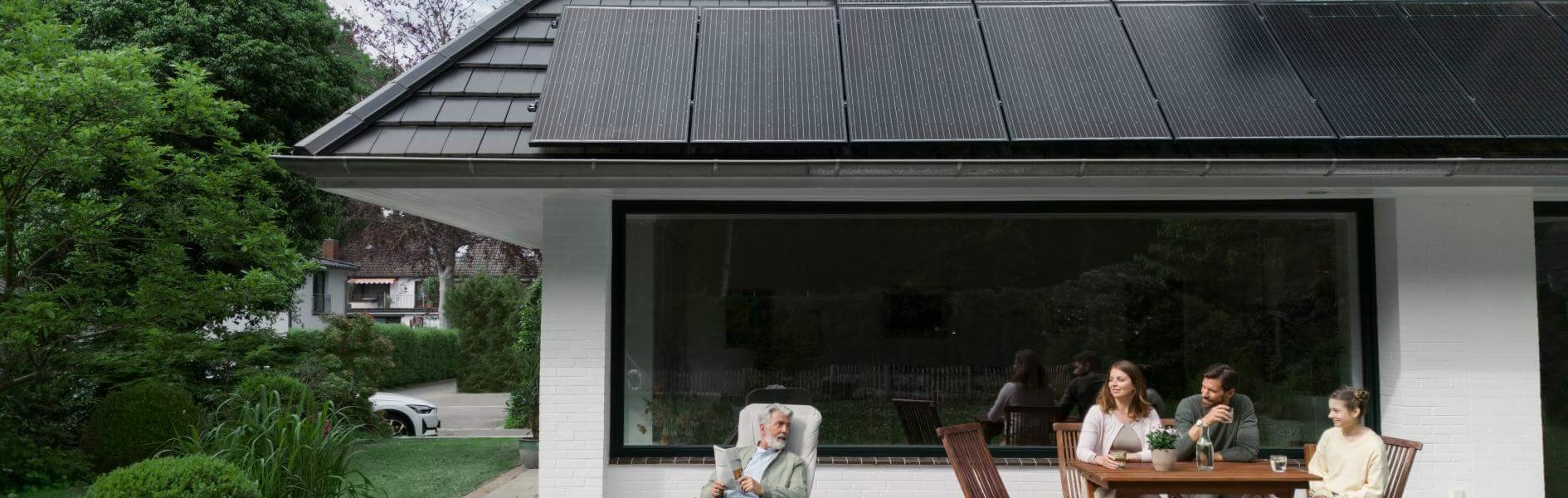 Familie vor Haus mit Solarpanelen