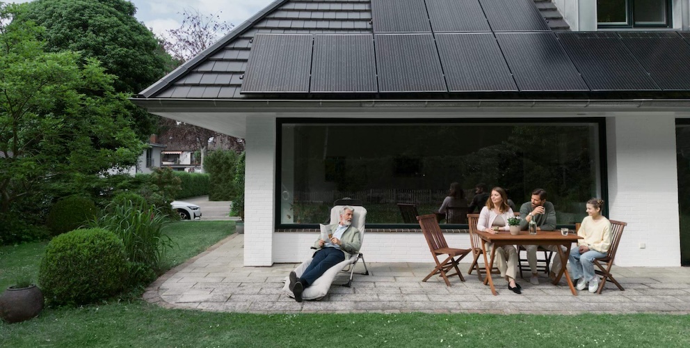 Familie vor Haus mit Solarpanelen