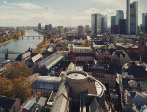 Blick über die Skyline von Frankfurt mit dem Main und den Wolkenkratzern im Vordergrund.