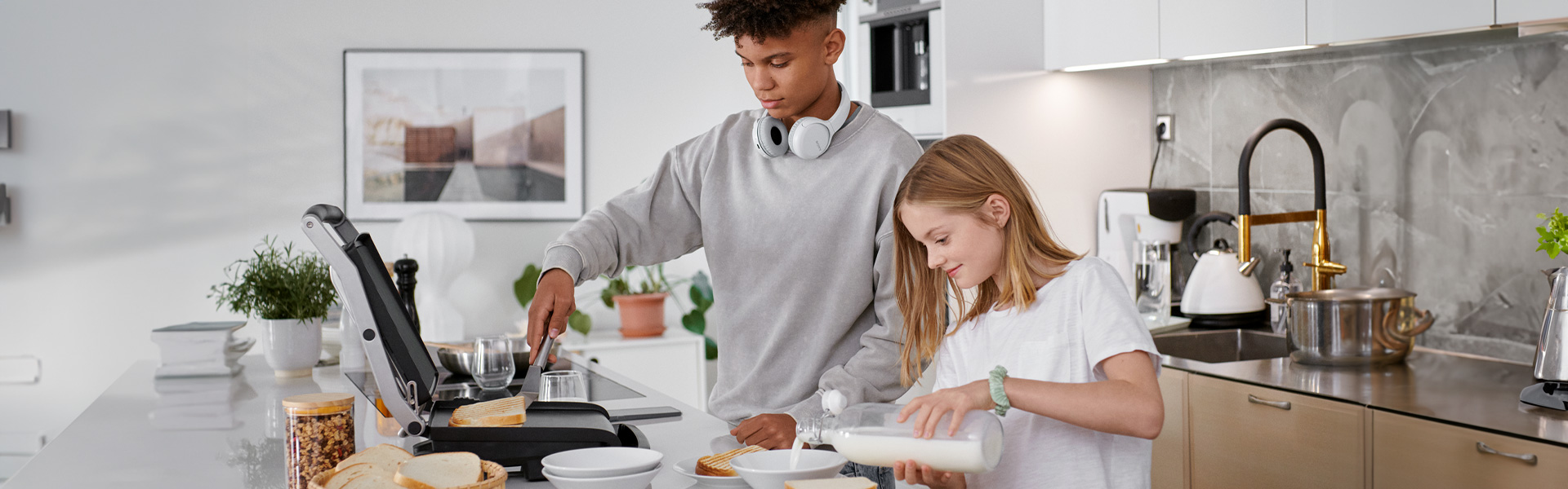 2 Jugendliche bereiten Essen in der Küche zu.