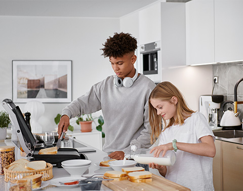 2 Jugendliche bereiten Essen in der Küche zu.
