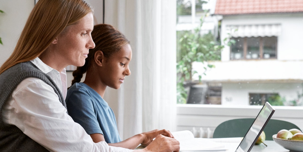 Mutter und Kind arbeiten zusammen am Schreibtisch