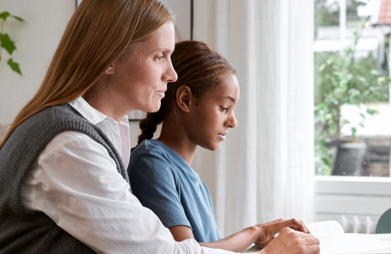 Mutter und Kind arbeiten zusammen am Schreibtisch