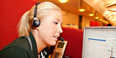 Junge, blonde Frau mit Headset
